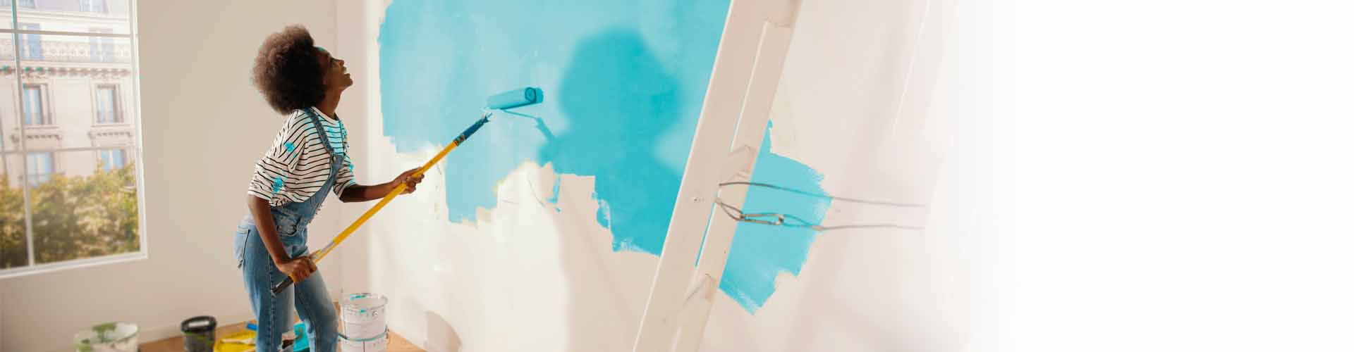 Woman painting blue wall