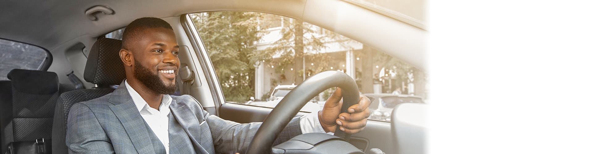 Carousel_VehicleLoans2021 Man wearing gray suit driving car