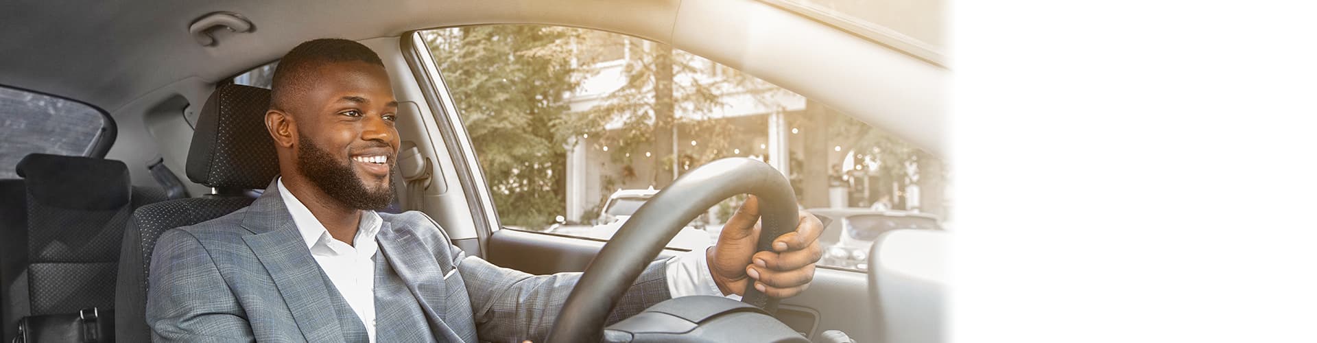 Man wearing gray suit driving car