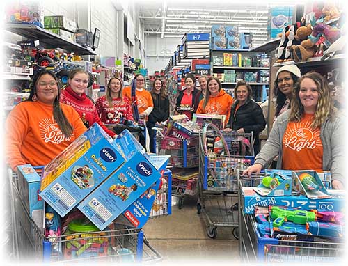 Group of people standing behind shopping carts filled with toys