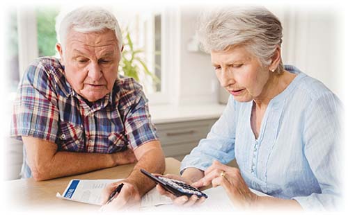 Two elderly people looking at a phone