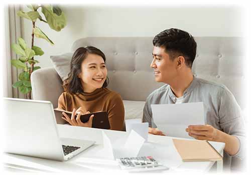 Woman wearing brown shirt talking to young man about finances