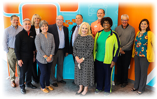 Staff of Ascentra Credit Union standing in front of orange and blue backdrop