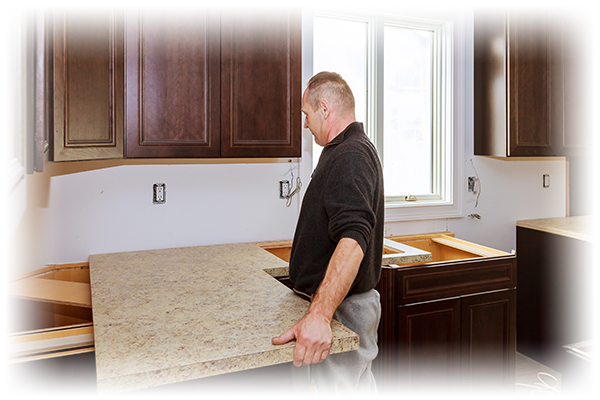 Man installing counter top in kitchen.