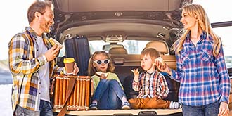 Happy family eating lunch in back of car