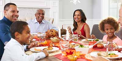 Family sitting around table smiling and eating