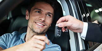 Man sitting in car getting handed keys ES