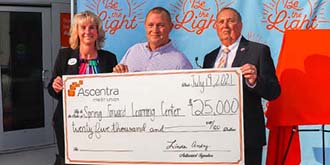 Ascentra staff standing with Spring Forward Learning Center staff during check presentation ES