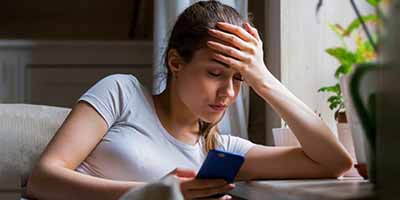 Person looking at their credit card in distress