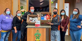 Ascentra Muscatine branch holding up 2 cardboard boxes of the food they collected during the food drive.