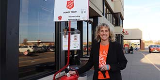 Linda Andry dropping money into salvation army red kettle