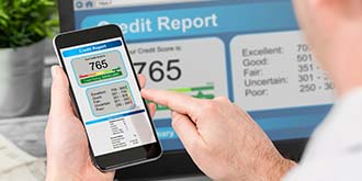 Someone holding phone that shows a 765 credit score ES