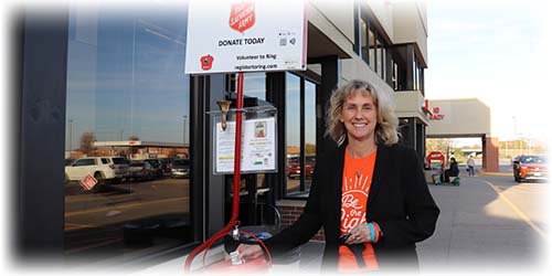 Linda Andry dropping money into salvation army red kettle