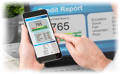 Phone showing a 765 credit score in front of a computer screen showing the same graph