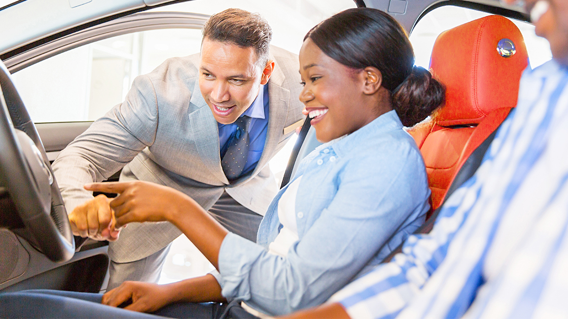 Woman being showed car features by salesman