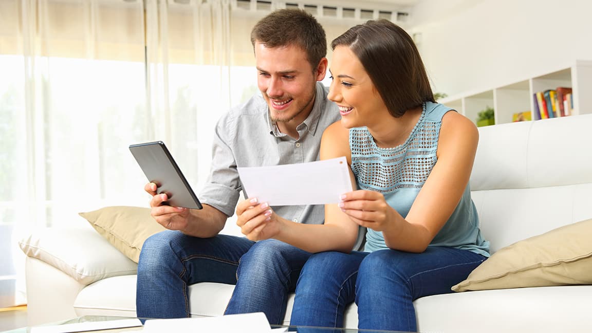 Couple paying bills via phone Couple paying bills via phone