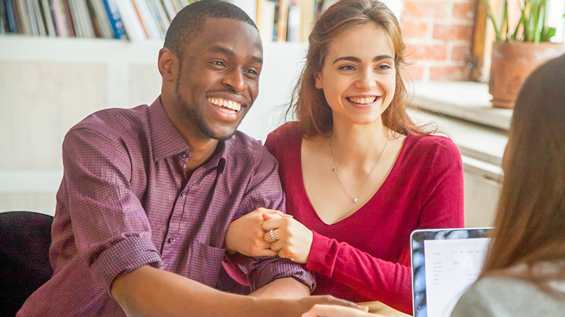 Happy couple sitting with loan officer