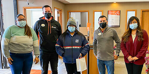 Group of Ascentra staff standing with USPS worker on random acts of kindness day