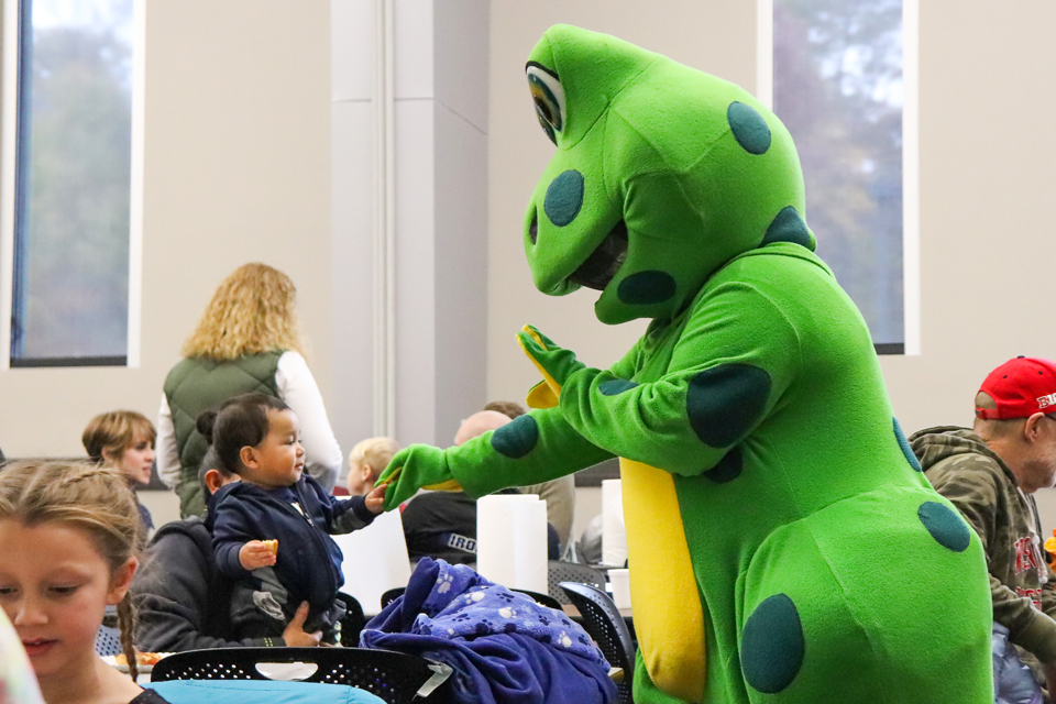 Jumpin George mascot high fives a little boy.